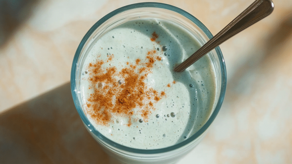 Does the Blue Salt Trick Really Work? The Truth About This Viral Stamina Boost 6 Top view of a glass filled with Blue Salt Trick Drink, topped with cinnamon powder and a metal spoon on a marble background.