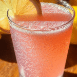 The Pink Salt Trick Recipe: Does This Viral Weight Loss Hack Really Work? 7 Pink Salt Trick drink in a clear glass with lemon slice on a wooden surface.