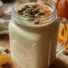 Bariatric Pumpkin Seed Recipe in a mason jar topped with pumpkin seeds, surrounded by oats and turmeric with fresh pumpkin in the background.