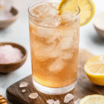 Japanese Pink Salt Recipe: The Natural Detox & Hydration Elixir 5 Refreshing Japanese pink salt drink with ice and lemon slice on a wooden board, surrounded by pink salt crystals.