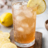 Glass of Japanese pink salt recipe drink with lemon slices and pink Himalayan salt on a marble background.