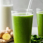 Detox Island Green Smoothie: The Best Tropical Cleanse for a Healthier You 5 Glass of Detox Island Green Smoothie on a white surface.