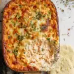Marry Me Chicken Dip Recipe: The Best Creamy Cheesy Appetizer You’ll Ever Try 6 Baked Marry Me Chicken Dip Recipe in a casserole dish topped with melted golden cheese and fresh herbs, served with flatbread.