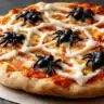 Close-up of a Spider Web Pizza topped with melted mozzarella in a web pattern and black olive spiders for Halloween.