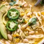 A warm, hearty bowl of Southwest White Chicken Chili made with tender shredded chicken, white beans, corn, and a hint of spice — topped with avocado, jalapeños, and cilantro for the perfect cozy meal.