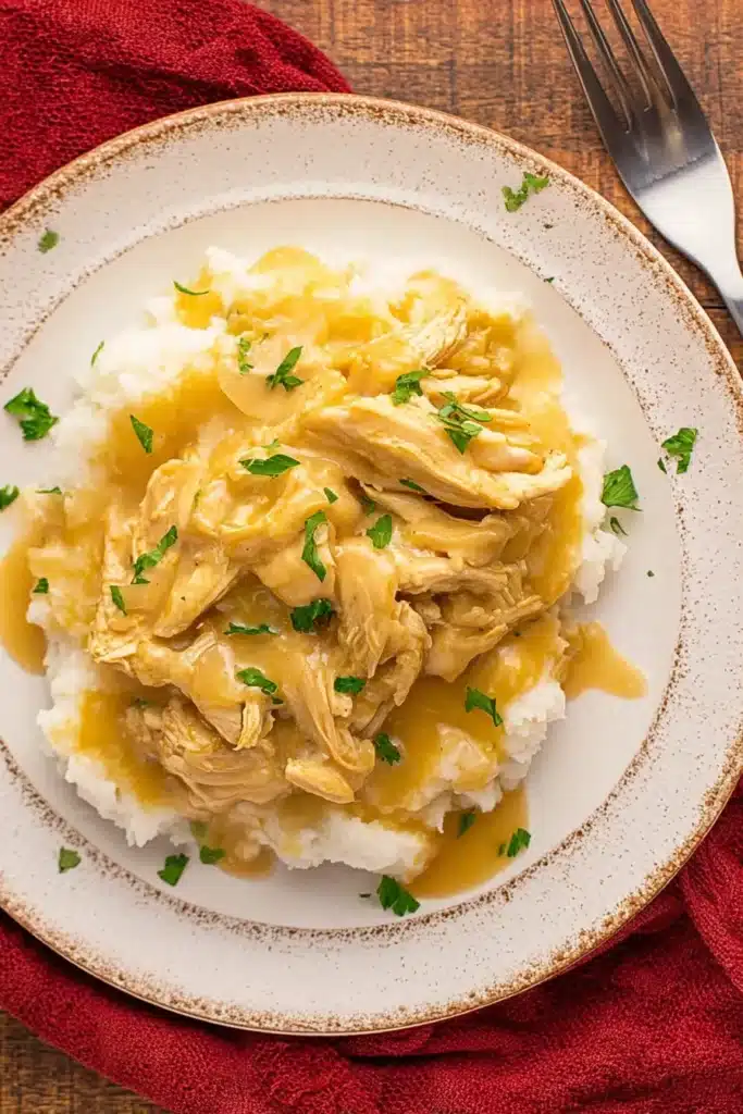 This creamy Crockpot Chicken and Gravy is pure comfort food — tender shredded chicken coated in a rich gravy, served over fluffy mashed potatoes for a hearty, cozy meal.