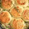 Golden skillet turkey pot pie with flaky biscuits on top and creamy turkey filling with peas and carrots.