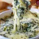 Warm, ultra creamy spinach and artichoke dip with stretchy melted cheese. This easy Cheesy Spinach and Artichoke Dip is the perfect appetizer for parties and holidays.