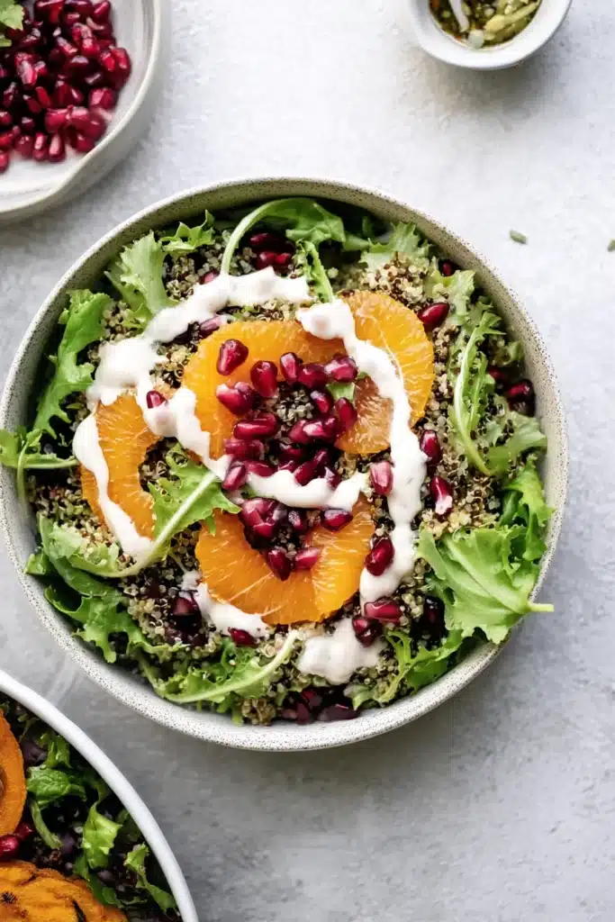 A colorful and refreshing winter salad made with crisp greens, juicy oranges, quinoa, and pomegranate, all drizzled with a zesty citrus ginger dressing.