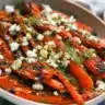Honey roasted carrots topped with crumbled feta and fresh dill in a rustic serving bowl.