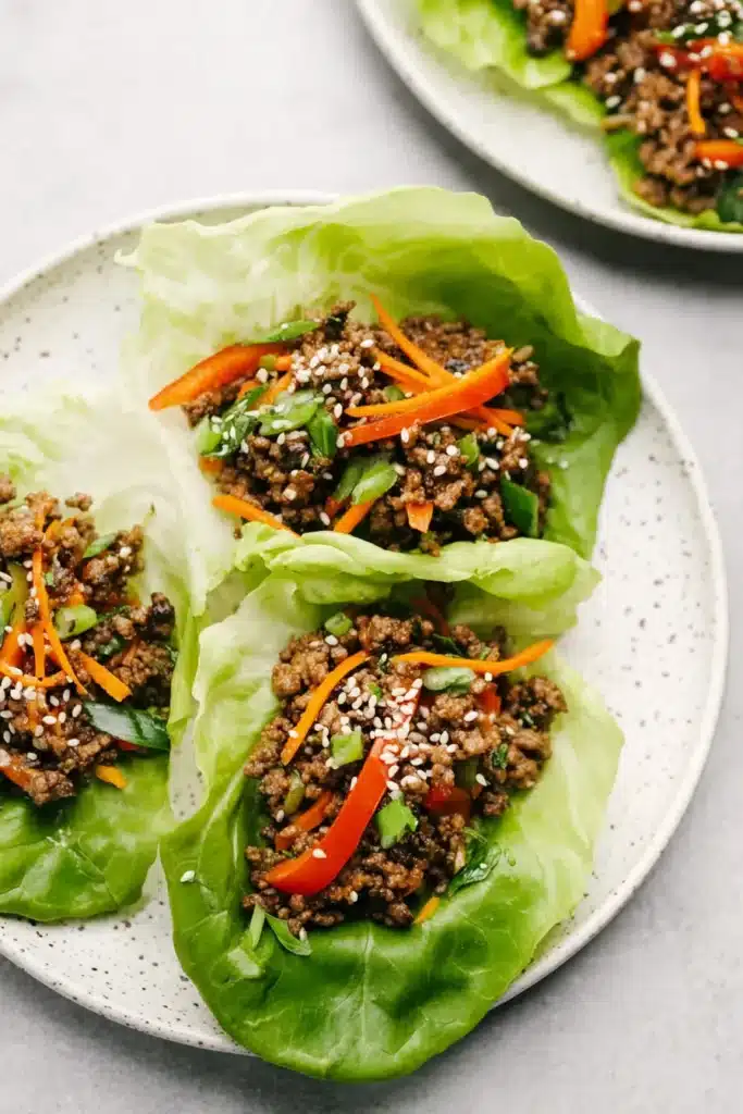 Flavorful ground beef lettuce wraps loaded with veggies and sprinkled with sesame seeds for a fresh, low-carb meal.